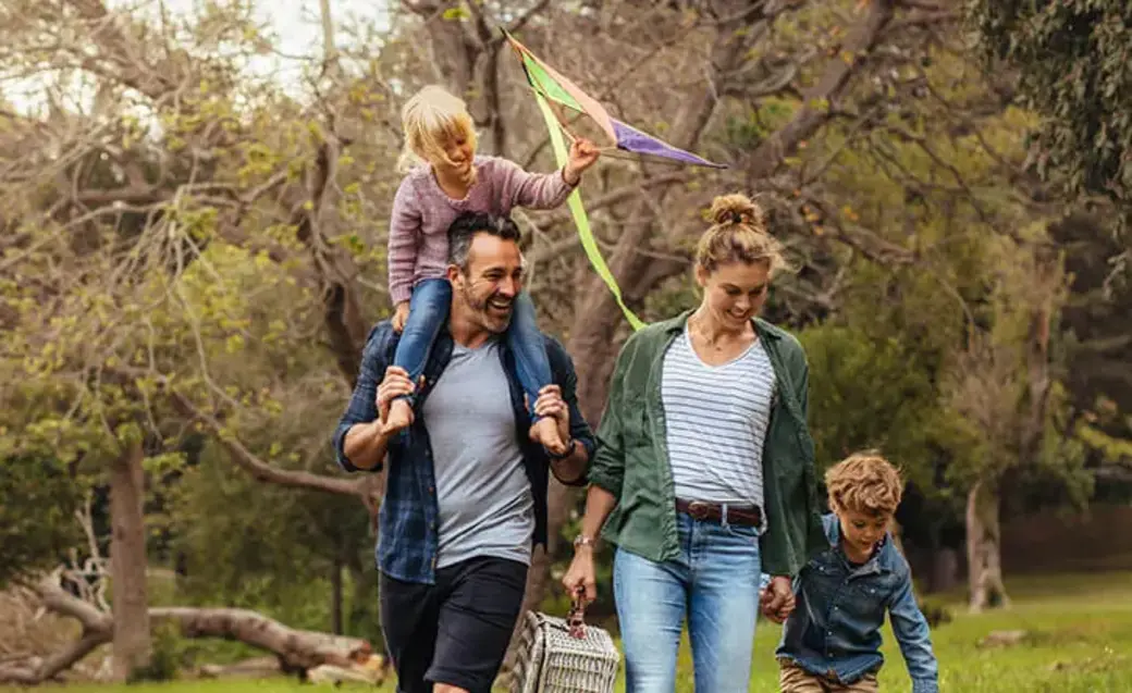 Familie mit zwei Kindern und Hund draußen